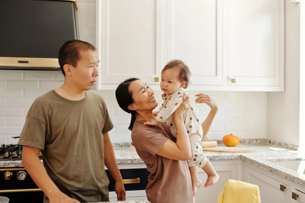 Một gia đình người Việt trẻ ở Houston bế em bé mới sinh tại nhà — sinh con là một sự kiện đời sống mở Special Enrollment Period để ghi danh bảo hiểm ACA