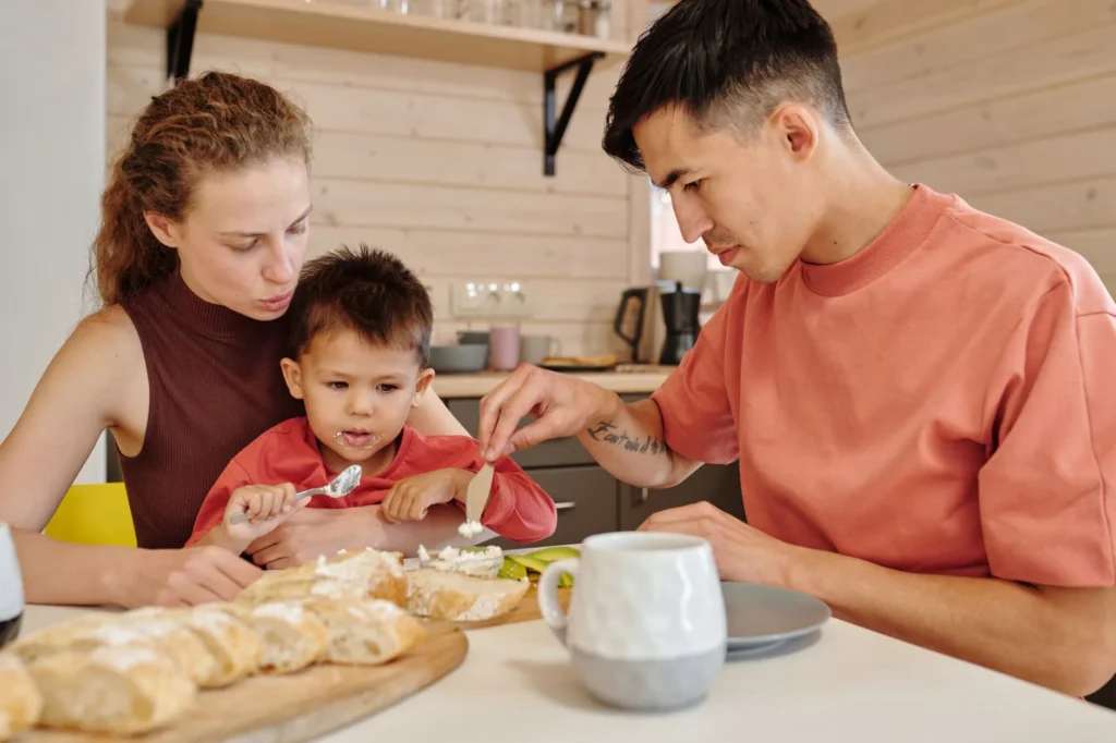 Một gia đình người Việt trẻ ngồi ở bàn bếp xem lại giấy tờ bảo hiểm sức khỏe cùng một chuyên viên — kiểm tra xem sự kiện đời sống nào mở Special Enrollment Period