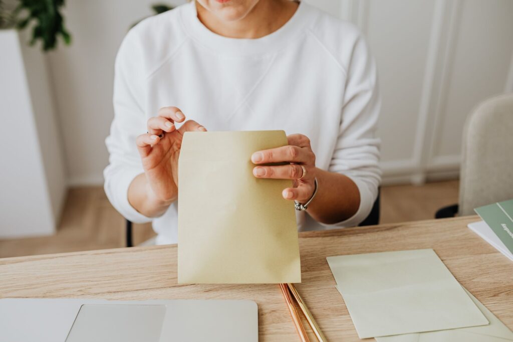 Một cụ cao niên người Việt đọc kỹ thư ANOC (Thông Báo Thay Đổi Hàng Năm) từ hãng bảo hiểm gửi tới trước ngày 30/9