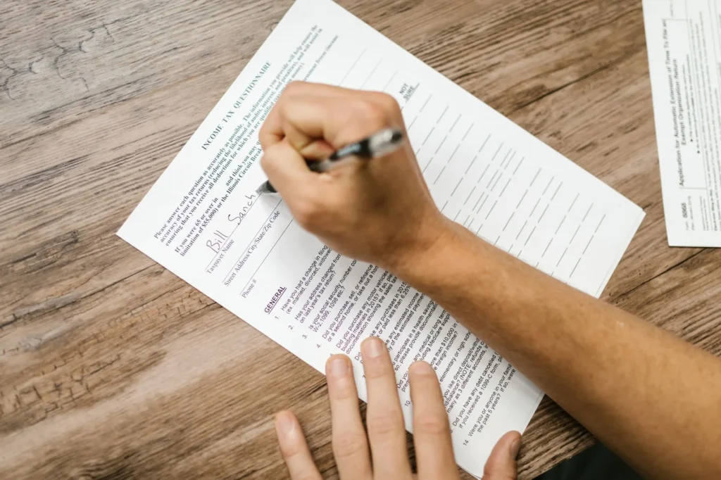 Tờ khai thuế và máy tính trên bàn — MAGI từ tờ khai thuế quyết định mức IRMAA Medicare của quý vị